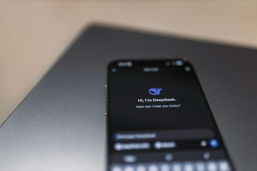 Un smartphone posé sur une table affiche l'interface textuelle de l'application DeepSeek.