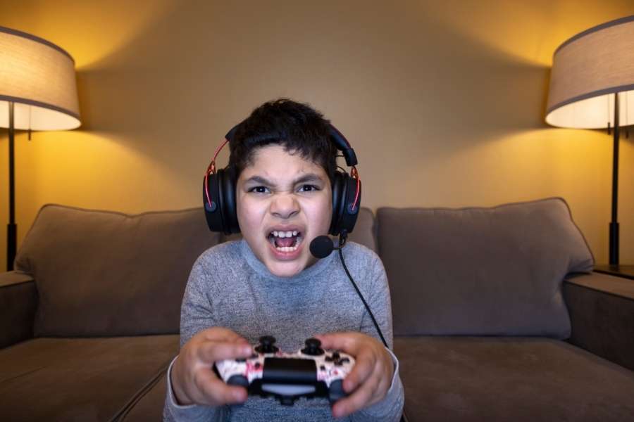 Un jeune garçon joueur porte un casque audio et tient une manette tout en criant de frustration, illustrant l'univers de Star Wars Zero Company.